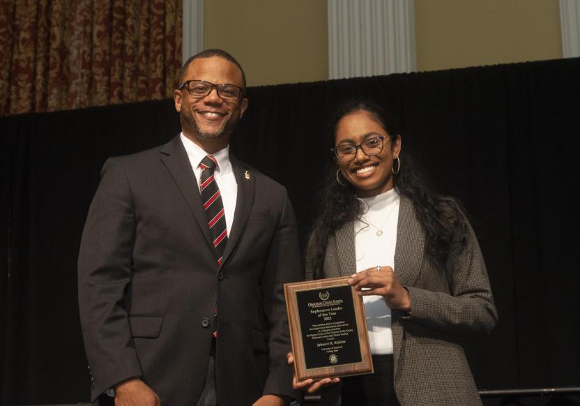 Two individuals on stage at University Awards Program